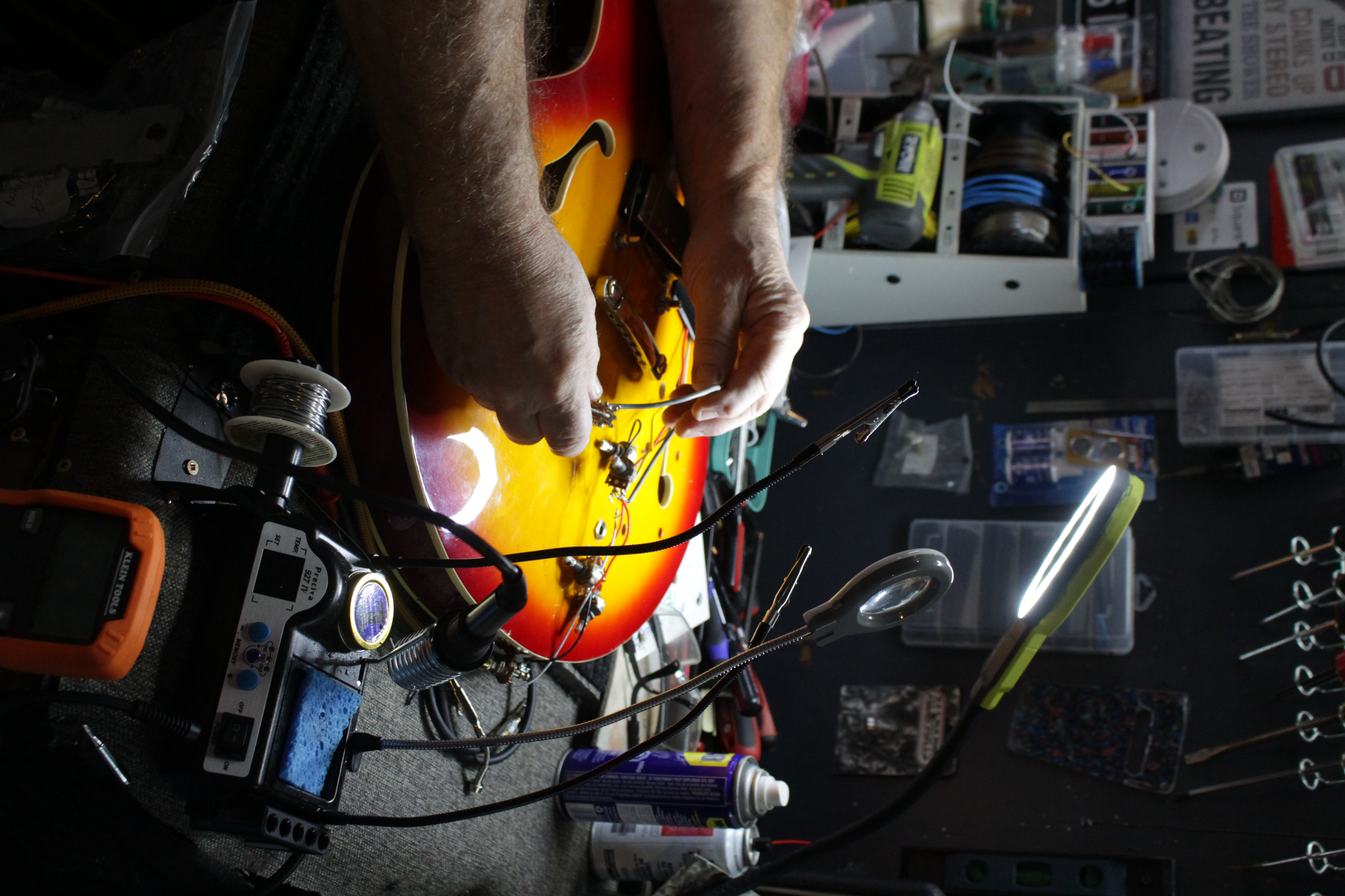 Close-up of professional guitar electronics repair and soldering work