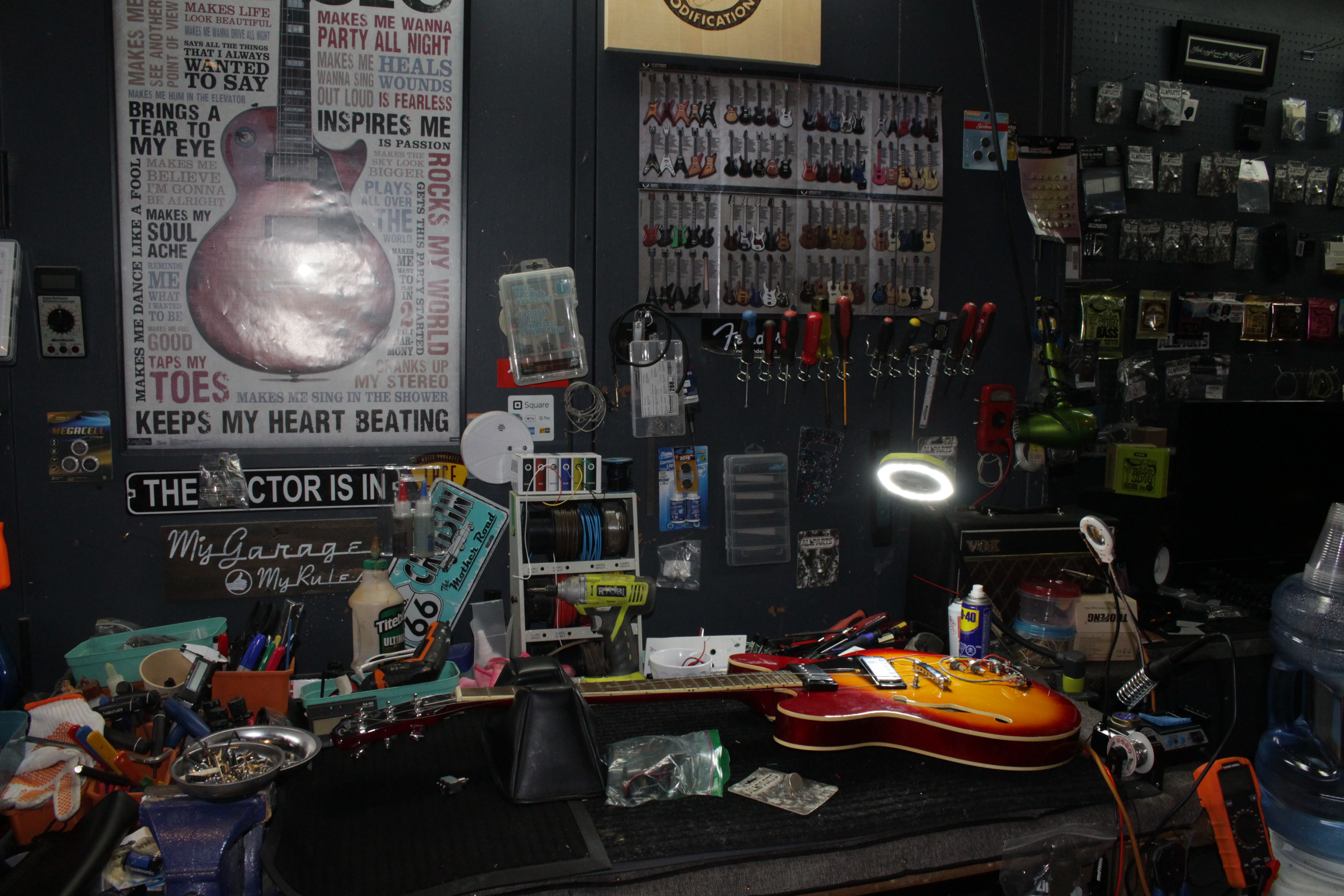 Guitar repair workbench featuring specialized tools and work in progress