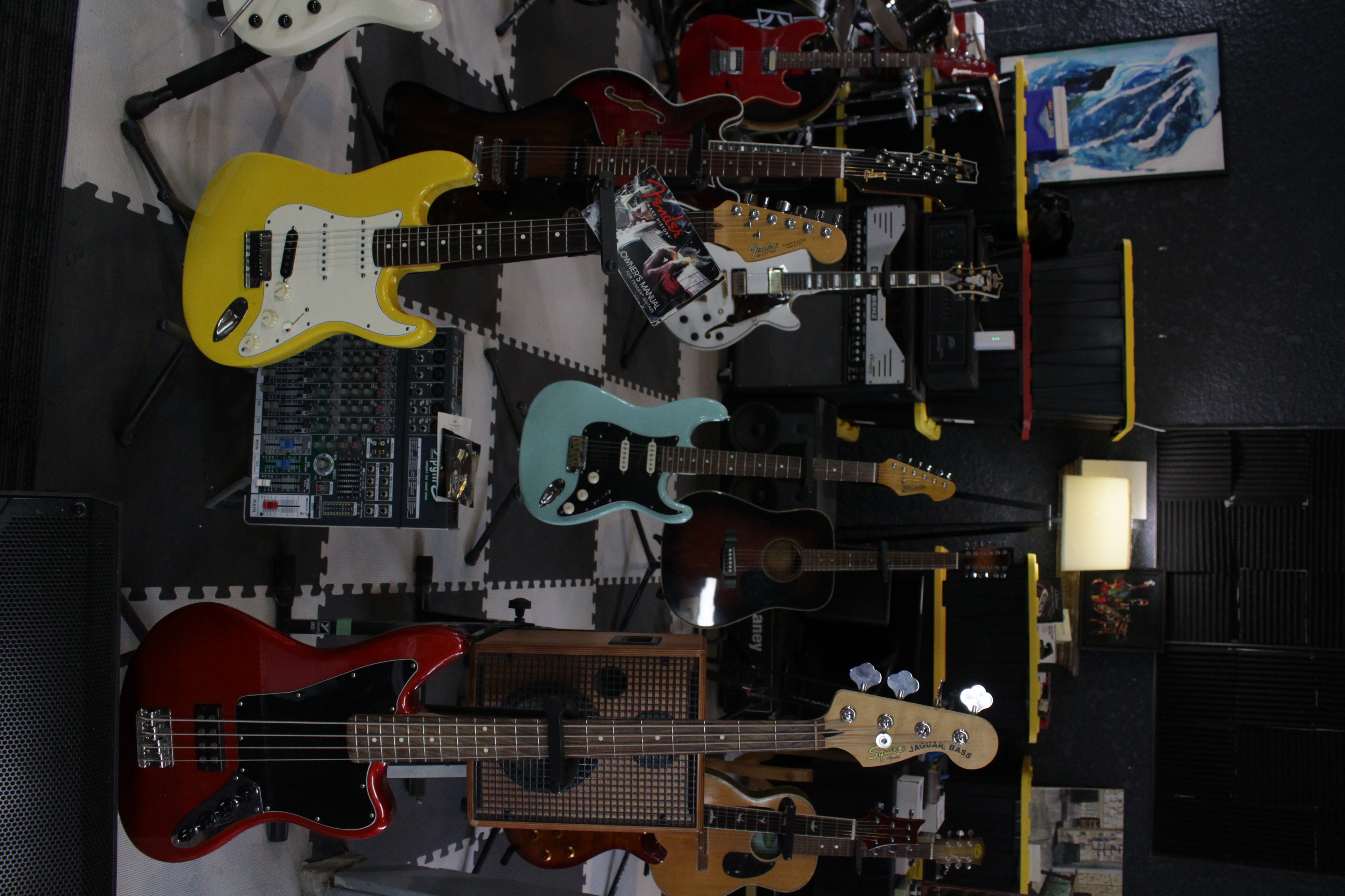 Colorful collection of electric and acoustic guitars wall display