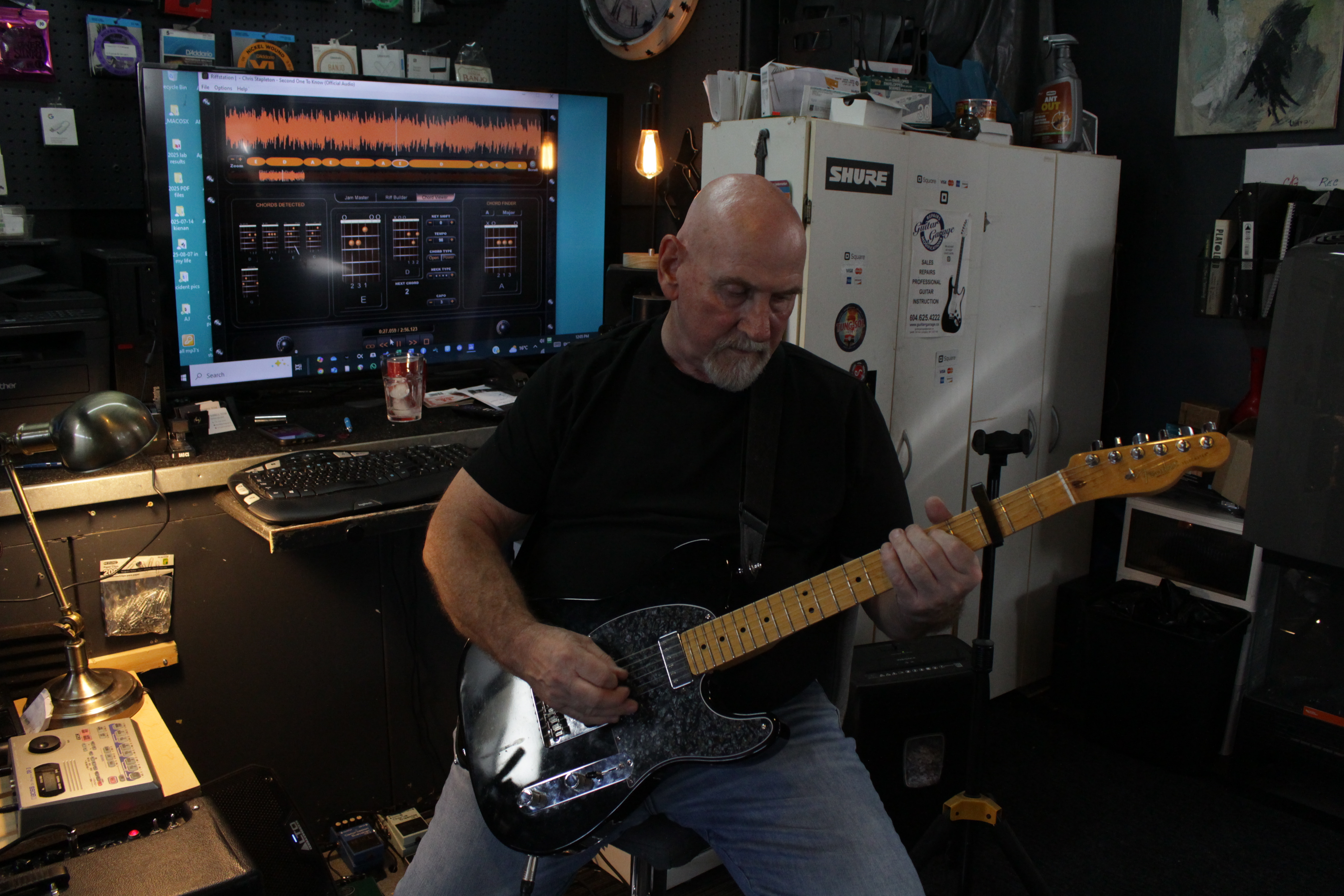 Technician playing electric Telecaster guitar in professional studio environment